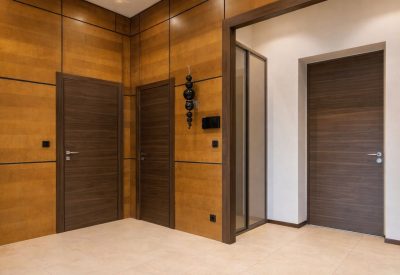 Moderna mörka innerdörrar monterade i en elegant hall med träpaneler.